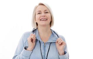 mulher alegre feliz vestindo seu cabelo branco regozijando-se com notícias positivas ou presente de aniversário, olhando para a câmera com um sorriso alegre e encantador. mulher loira relaxando dentro de casa depois do trabalho foto