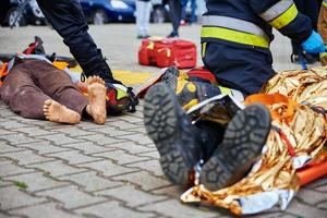 socorristas providenciar primeiro ajuda para a vítima durante carro estrada acidente foto