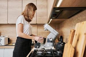 mulher cozinhando às preparando comida, usando Comida processador, foto