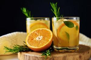 vidro do laranja limonada em Sombrio fundo foto