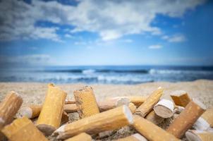 cigarro tocos desistiu e esquerda dentro uma pilha em uma lindo de praia foto