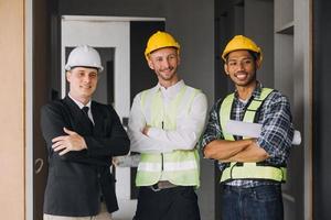 diverso equipe do especialistas usar tábua computador em construção local. real Estado construção projeto com Civil engenheiro, arquiteto, o negócio investidor e geral trabalhador discutindo plano detalhes. foto