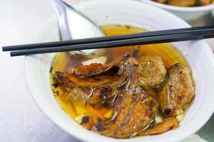 Bun cha com porco grelhado, macarrão de arroz, legumes e sopa na culinária vietnamita foto