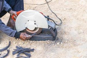 do homem mão usando ferro cortador dentro a ambiente de trabalho, fixação ferro marquise quadro, Armação com fagulha. trabalhador corte aço com elétrico ferro cortador. aço cortador moedor corte ferro tubo com brilhante faíscas. foto