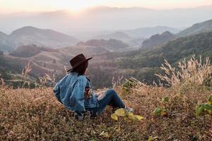 mulher sentada em uma montanha foto