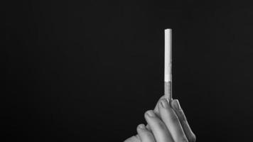 preto e branco de uma mão segurando um cigarro foto