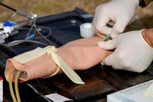 uma médico fornecedor praticando inserindo a iv cateter foto