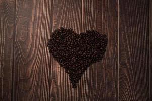 grãos de café dispostos em forma de coração, adoro beber café conceito foto