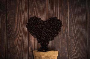 grãos de café dispostos em forma de coração, adoro beber café conceito foto