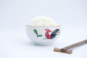 arroz dentro uma cerâmico tigela com de madeira pauzinho em branco fundo foto