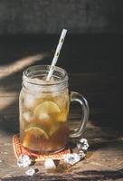 gelo limão chá dentro a vidro com Lima fatias foto