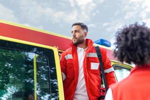 uma equipe do paramédicos é chegando Fora do a ambulância, respondendo para a emergência chamar. foto