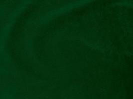 textura de tecido de veludo verde escuro usado como plano de fundo. fundo de tecido verde vazio de material têxtil macio e liso. há espaço para o texto. foto