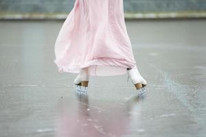 fechar-se do fêmea pernas em branco figura patins dentro inverno às a ao ar livre gelo pista. foto