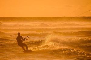 kitesurfer às pôr do sol foto