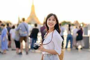 retrato jovem lindo ásia mulher sorridente enquanto viagem às wat uma corrida pôr do sol Visão apontar, Bangkok, tailândia. foto