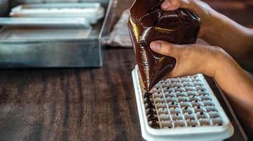 fechar acima do mão chefe de cozinha fazer caseiro chocolate bares foto