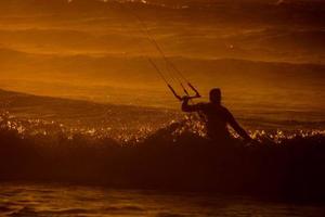 kitesurfer às pôr do sol foto