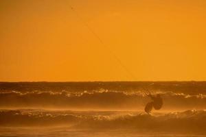 kitesurfer às pôr do sol foto