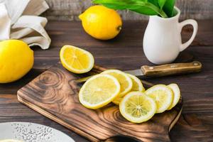 corte maduro limões com uma faca em uma de madeira corte borda em a mesa. orgânico nutrição, fonte do vitaminas. foto