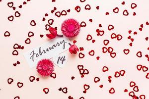 dia dos namorados dia. encontro do fevereiro 14 e seco flores em uma Rosa fundo espalhado com corações topo Visão foto
