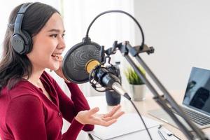 ásia mulher é Falando para encorajar em uma rádio transmissão estação. lindo fêmea organizado a rádio programa. rádio, podcast, viver fumegante, entretenimento, ouvir, tecnologia, música, alto falante foto