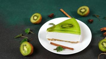 bolo de queijo com kiwi, canela bastão e folhas hortelã em uma verde fundo. cópia de cpase para texto foto