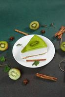 bolo de queijo com kiwi, canela bastão e folhas hortelã em uma verde fundo. cópia de cpase para texto foto