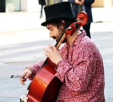 Bolonha, Itália, abril 16, 2022, rua artista, jogando violoncelo dentro a histórico centro da cidade distrito do bolonha. busking em rua conceito. foto