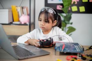 Ásia alunos aprender às casa dentro codificação robô carros e eletrônico borda cabos dentro tronco, vapor, foto