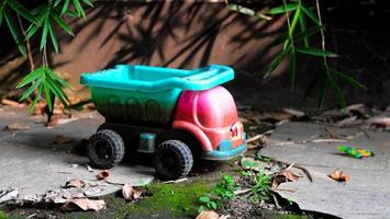 uma fechar-se do uma velho brinquedo carro dentro a jardim oxidado fundo foto