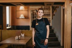 uma jovem garçonete está posando em um restaurante foto