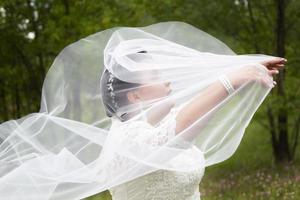 a gordo noiva coberto ela mesma com uma Casamento véu. foto
