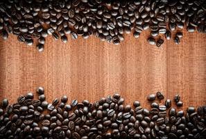 grãos de café sobre fundo madeira foto