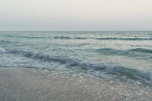 tom vintage desbotado das ondas do mar na praia durante o verão foto