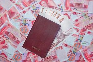 Passaporte com tailandês baht em yuan moeda fundo foto