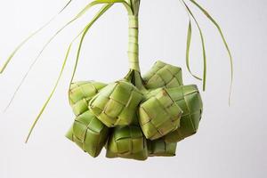 ketupat Lebaran é uma típica indonésio Comida durante a festivo estação do ketupat, eid al fitr, eid al adha, natural arroz embrulho fez a partir de jovem coco folhas em uma branco fundo, esvaziar espaço foto