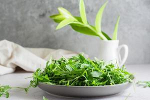 fresco folhas do Rúcula em uma prato em a mesa. orgânico dieta vegetariano Comida. estilo de vida. cópia de espaço foto