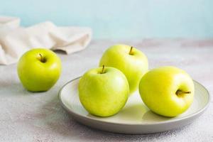 fresco verde maçãs em uma prato em a mesa. desintoxicação dieta. estilo de vida foto