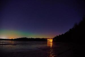 aurora boreal sobre um lago congelado em Littoinen, Finlândia foto