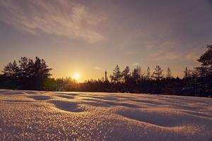 neve em primeiro plano em uma noite gelada de inverno ao pôr do sol foto