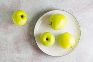 fresco verde maçãs em uma prato em a mesa. desintoxicação dieta. estilo de vida. topo Visão foto
