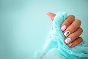 fêmea mãos com uma lindo manicure em uma azul fundo. foto