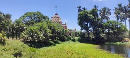 a a Principal portão do rajbari dentro natore distrito do Bangladesh dentro a ásia continente, é isto chamado uttara ganabhavan a real Palácio azul céu verde árvores lago e têmpora agradável Visão foto para papel de parede