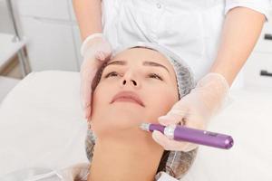 cosmetologista faz mesoterapia injeção para rejuvenescimento mulher face, procedimento dentro beleza salão foto