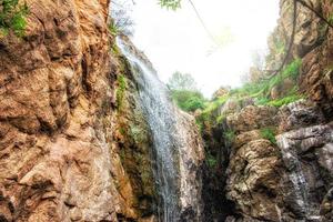 água em cascata baixa uma Rocha face foto