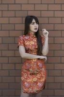 retrato lindo ásia mulher dentro cheongsam vestido, tailândia gente, feliz chinês Novo ano conceito, feliz ásia senhora dentro chinês tradicional vestir foto