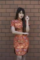 retrato lindo ásia mulher dentro cheongsam vestido, tailândia gente, feliz chinês Novo ano conceito, feliz ásia senhora dentro chinês tradicional vestir foto