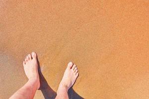 pés do homem na praia foto