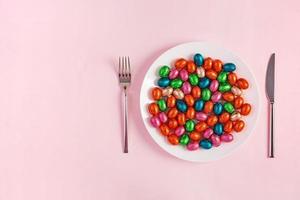 feliz Páscoa. mesa configuração para Páscoa feriado. Páscoa chocolate ovos e talheres em Rosa fundo. topo visualizar, plano deitar foto